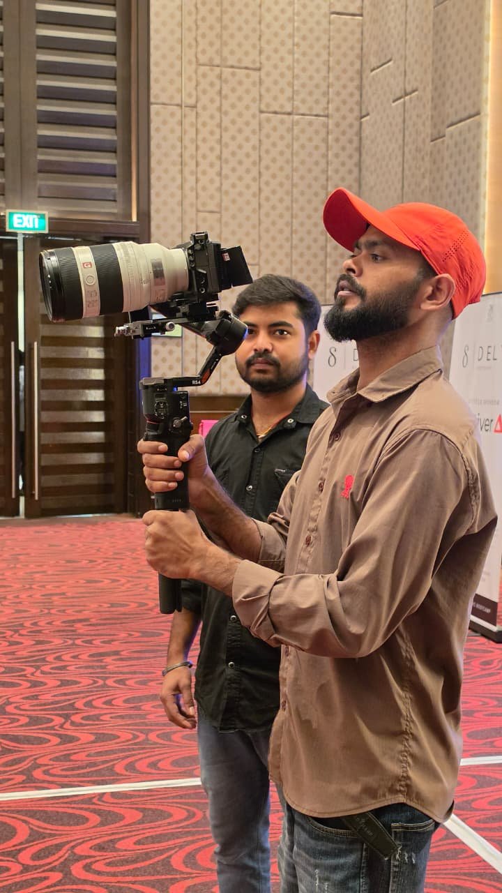 Cinematic360 cinematographer performing overhead gimbal sweep in hotel ballroom with crystal chandelier as dominant practical light source