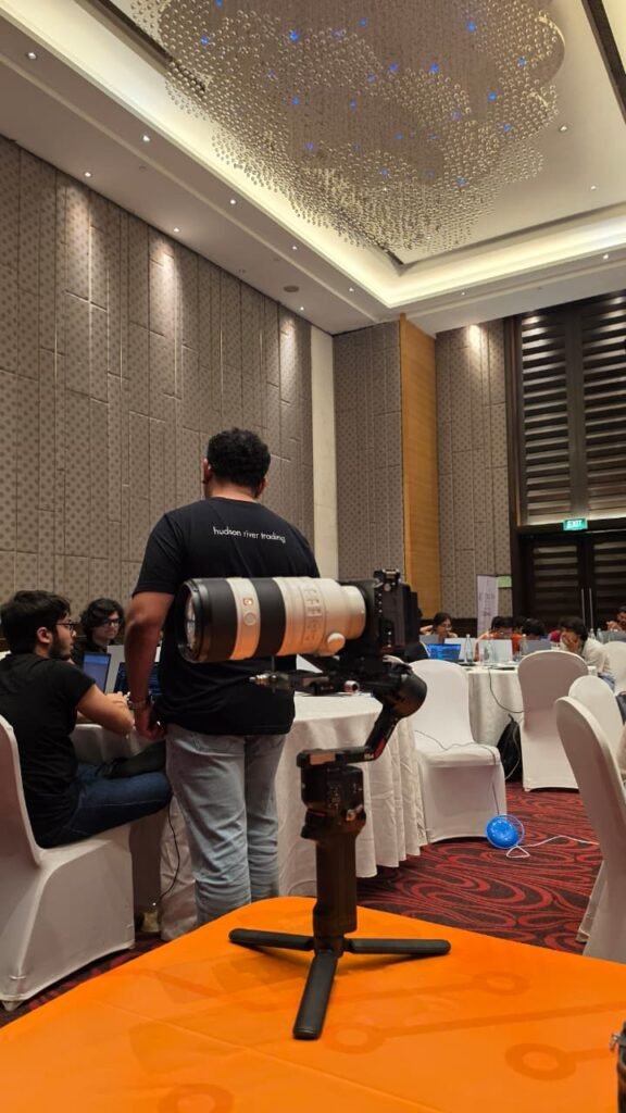 Large telephoto cinema lens and gimbal rig resting on portable tabletop tripod at corporate event by Cinematic360